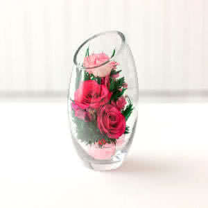 Лиловые и светло-розовые розы в овальной вазе со скошенным верхом