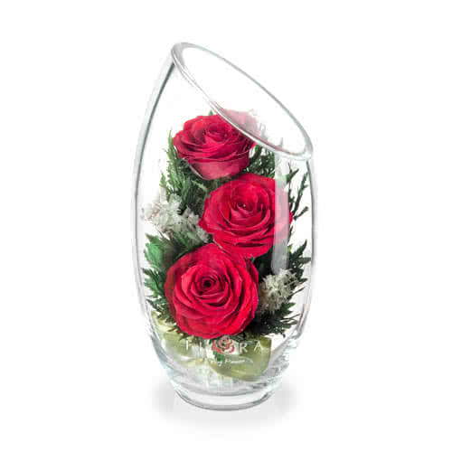 Красные розы в малой овальной вазе со скошенным верхом